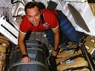 Carl Walz straps down a stowed Russian Orlan space suit